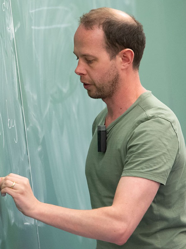 Lecturer writing on chalk board