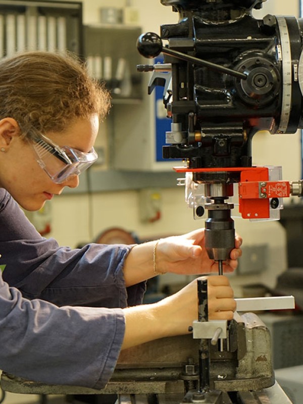 Student using mechanical engineering equipment