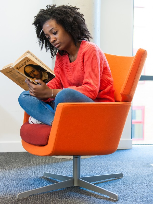 Student reading Shakespeare in the library