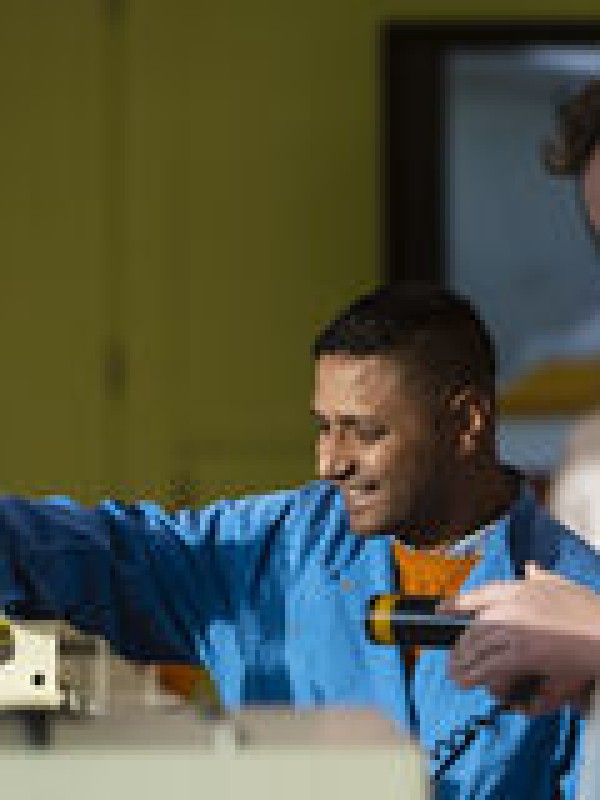 Two students in lab coats working in a laboratory