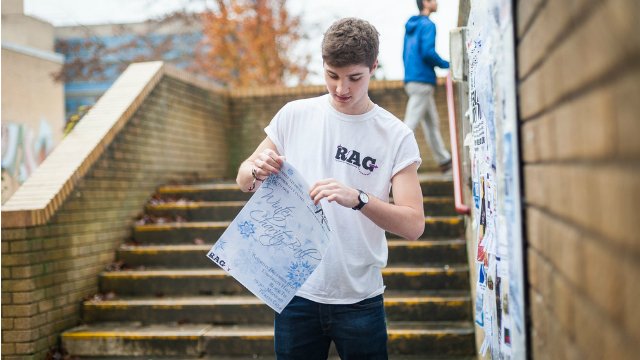 A male student putting up a poster