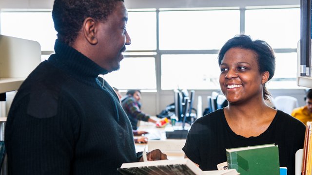 Male and female talking in library