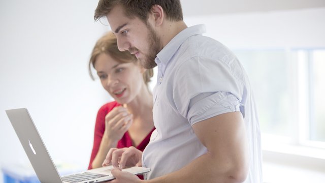 Male and female looking at a macbook