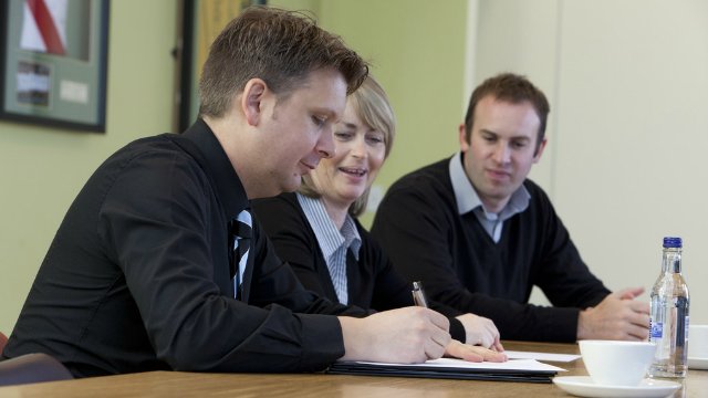 Three adults having a meeting