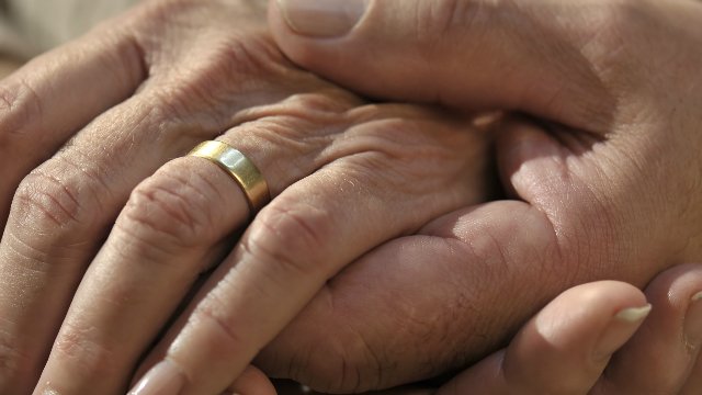 A senior couple holding hands