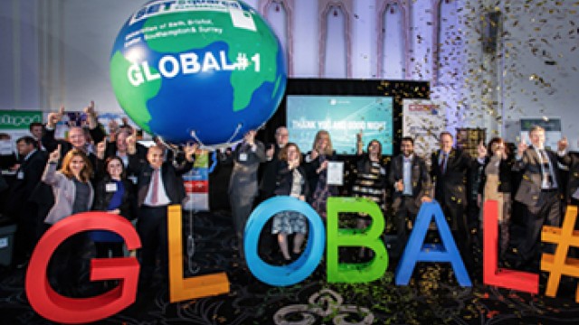 a group of people holding a large blow up globe and letters that spell out GLOBAL number 1