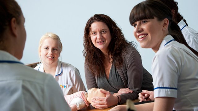 Midwifery students with a sim baby