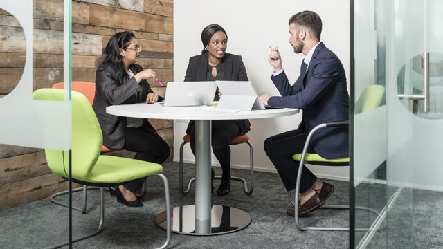 Group of people talking whilst sat around a table