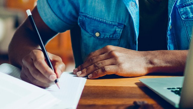 Male using pencil in notebook