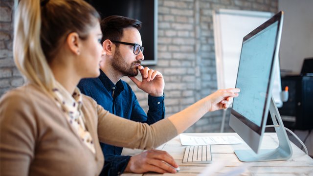 Male and female looking at computer screen