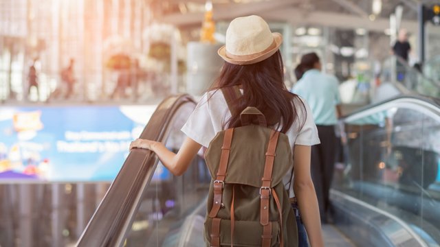 Female student at airport wearing backpack