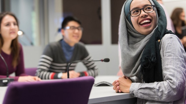 A group of students laughing together in a classroom