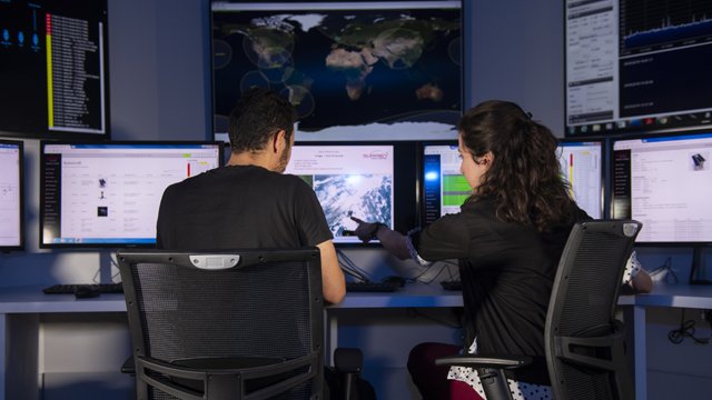 Student with screens showing weather forecasts