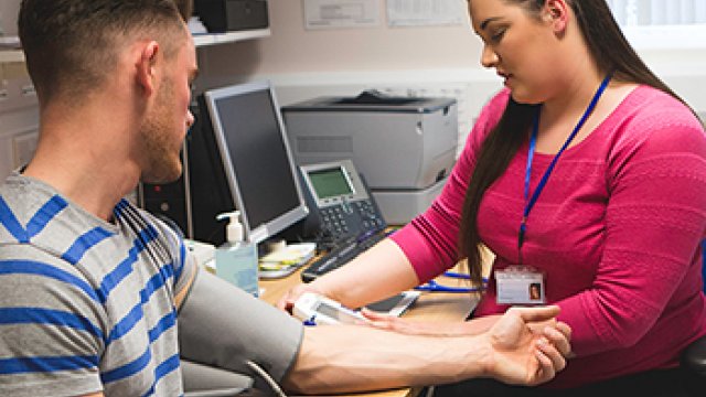 A nurse is taking a man's blood pressure