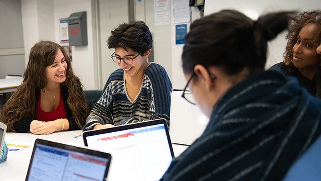 a group of psychology students are sitting around a table with their laptops