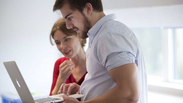 Woman and man looking at laptop screen