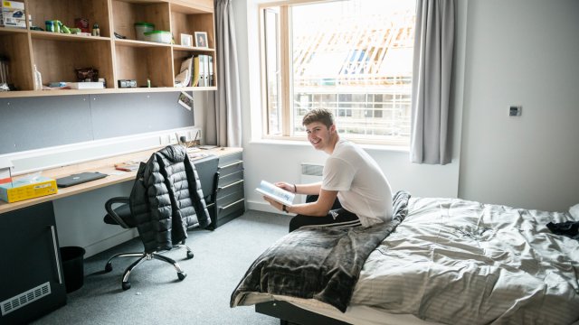 Student sat on bed in Manor Park accommodation