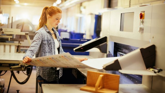 Woman holding industrial size sheet of paper.