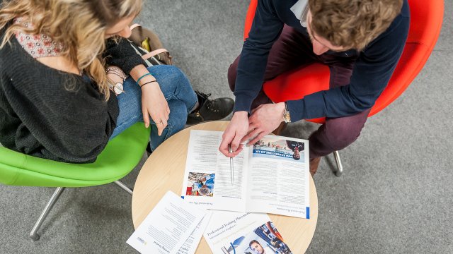 Careers adviser and student sitting at a table.