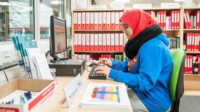 Female student sitting at a PC.