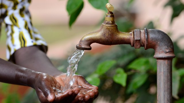 Hand cupping water coming out of a tap.