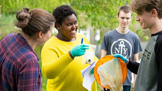 Biological science students taking samples from the campus lake during field work in preparation for testing later in the lab.