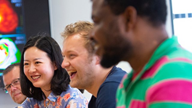 People sitting round a table, laughing.