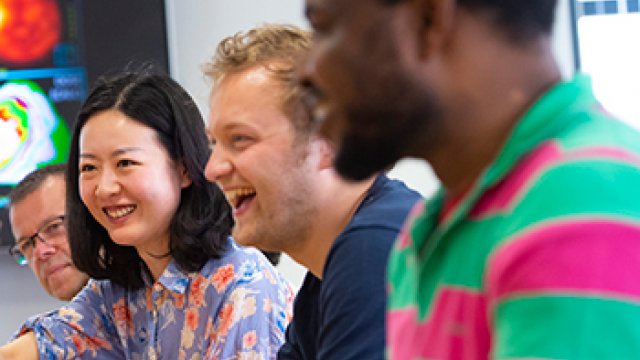 People sitting round a table, laughing.