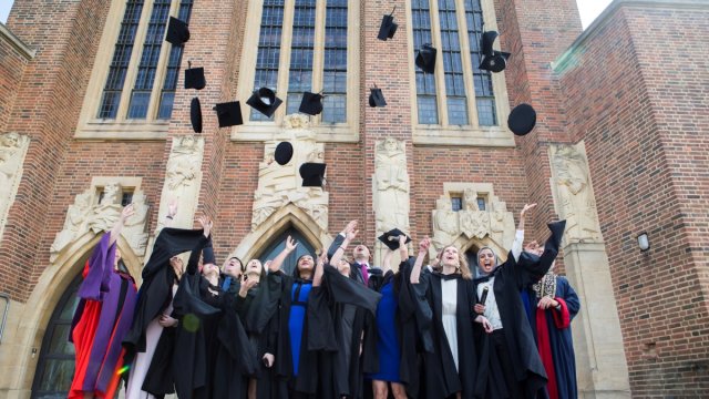 Graduates outside Cathedral throwing hats in the air