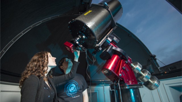 Woman using a large telescope