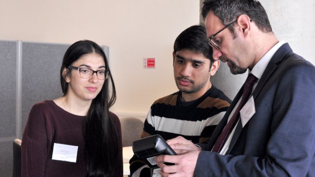 Man showing equipment to two students