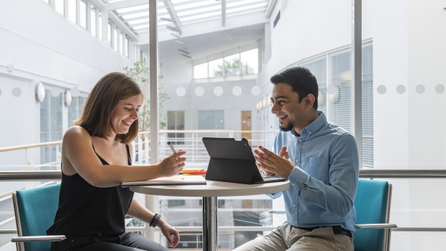 Two students working together and smiling