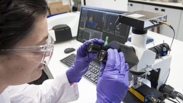 Female using a microscope