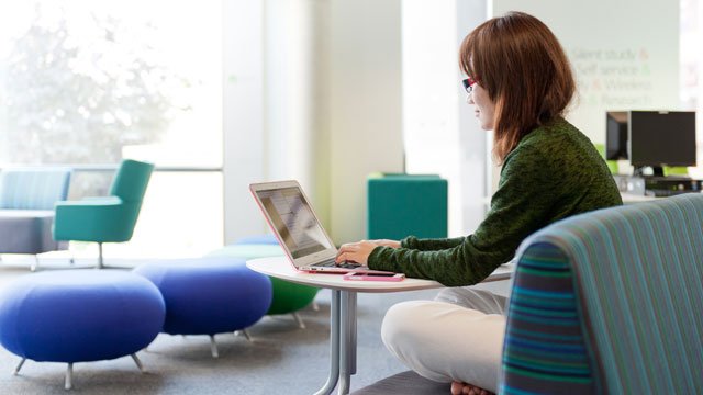 Female student studying in the Library on her laptop