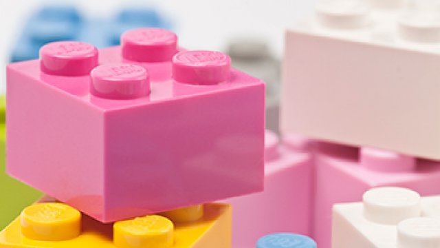 A close up of a pile of pink, blue, yellow and white Lego blocks