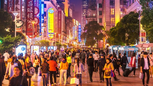 Crowds of people walking through city at night