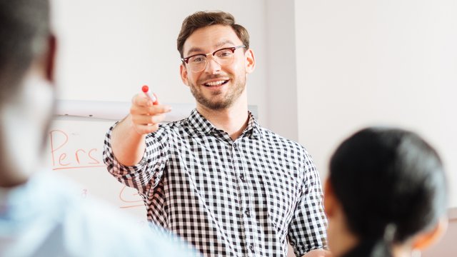 Male teacher point at student with pen