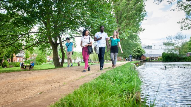 People walking beside the River Wey