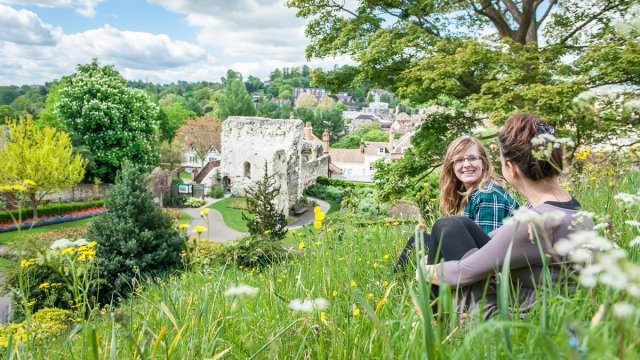 People sitting on the hill by Guildford Castle