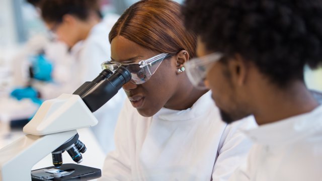 Female student looking through microscope