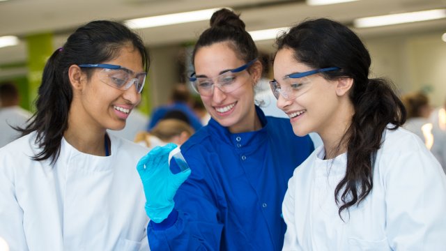 Supervisor showing students vial of liquid