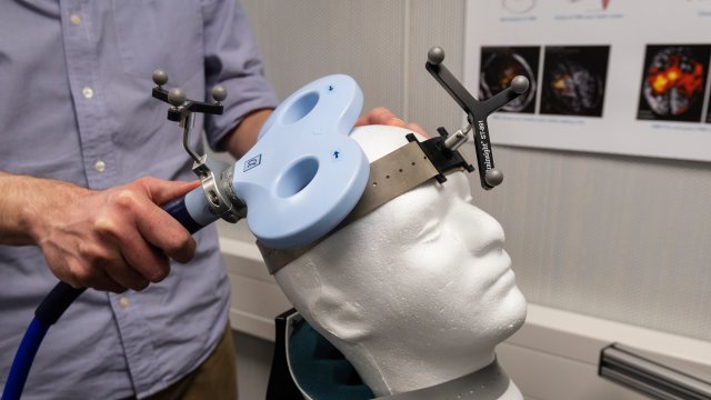 A transcranial magnetic stimulation (TMS) coil being demonstrated on a Styrofoam head. 