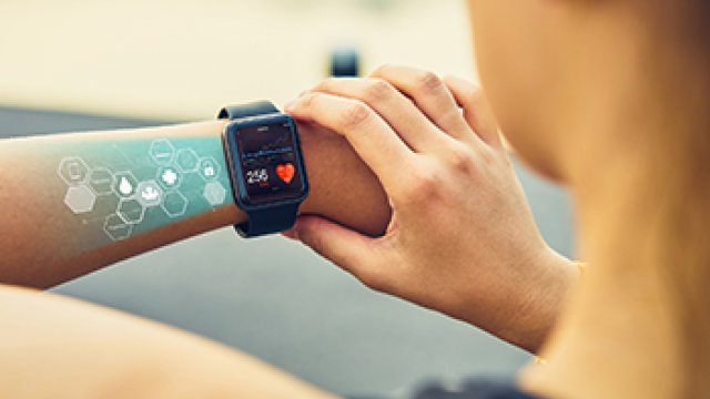 Young woman checking the sports watch with screen healthcare icon, measuring heart rate and performance after running