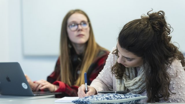 two female students writing on their notebooks