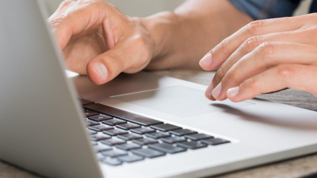 hands typing on a laptop keyboard 