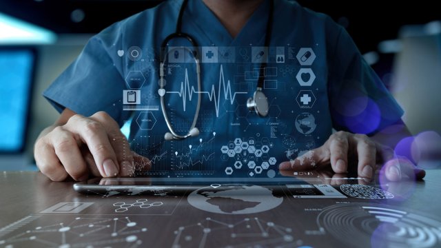 Health icons floating above tablet doctor is using