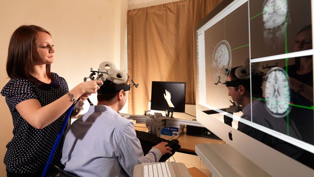 Using EEG & TMS machines with student/model, brain scan