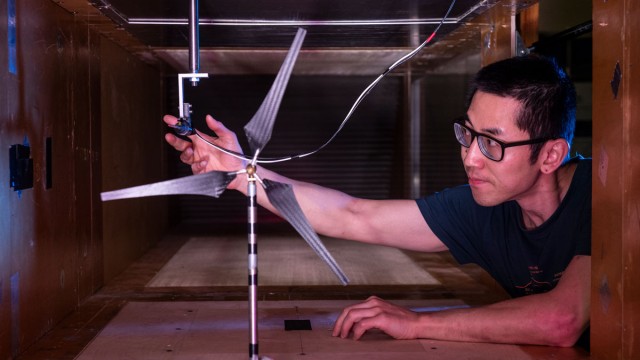 Student placing equipment into wind tunnel to test