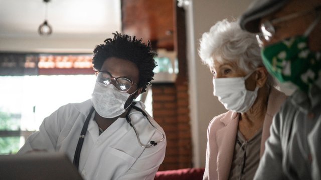 Doctor and patients sat together masked up