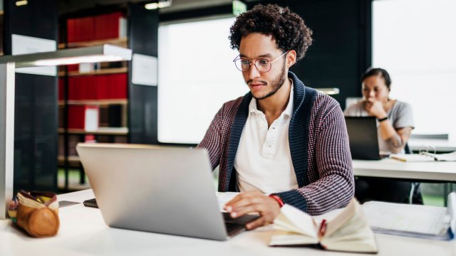 Man working on his laptop in a library.